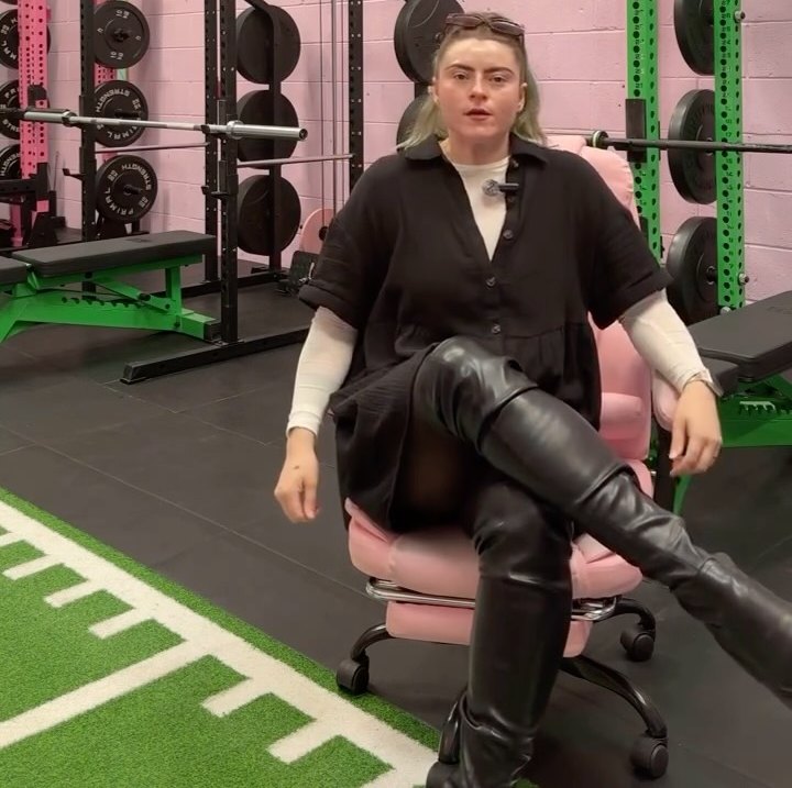 The studio floor with green and pink racks, a green turf track and a coach sitting on a pink chair
