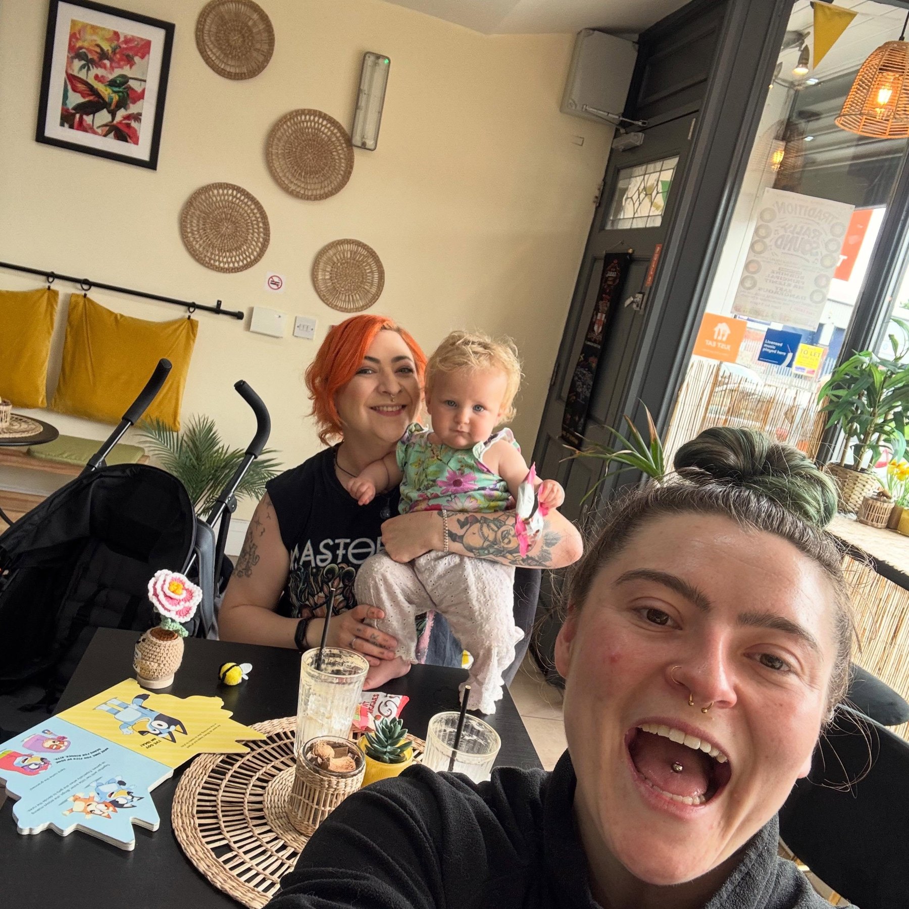 The coaches taking a selfie together at a café social, iced drinks on the table